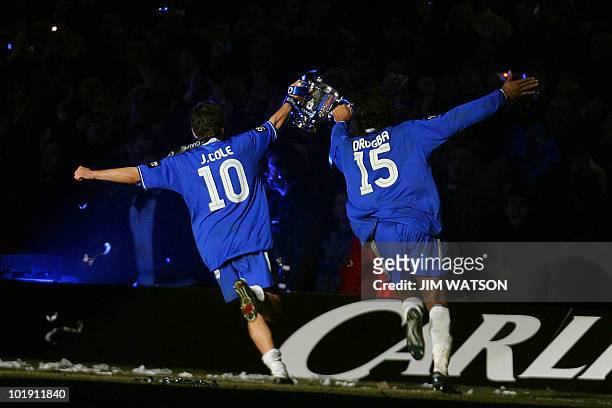 Chelsea's Joe Cole and Didier Drogba run with the Carling Cup trophy after defeating Liverpool in the Carling Cup Final football match at the...