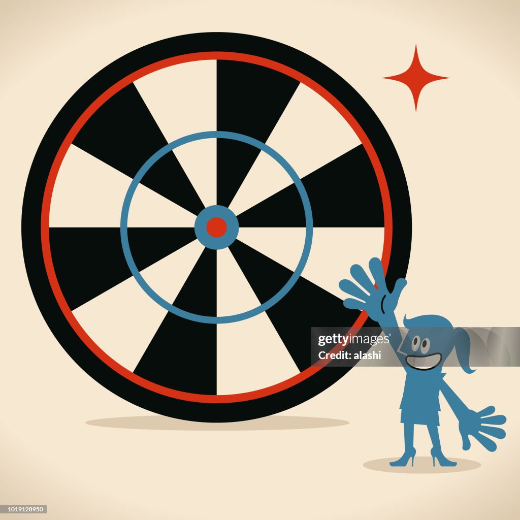 Smiling businesswoman (game show host) showing a big goal target dartboard