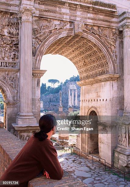 italy, rome, roman forum, woman looking at arch of septimus severus - roma fotografías e imágenes de stock