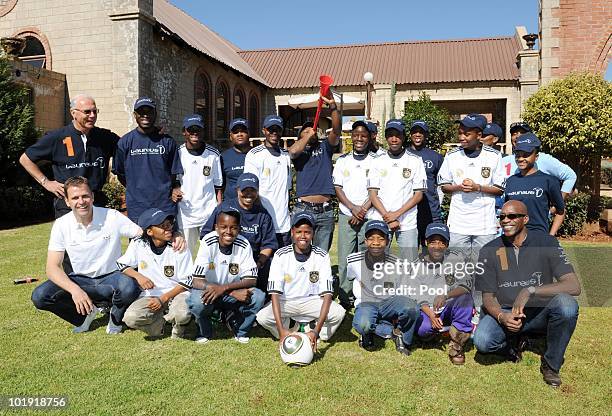 Edwin Moses, Laureus academy chairman and Franz Beckenbauer, Laureus academy member pose with children from the "Sport for all" Laureus 'Sport for...