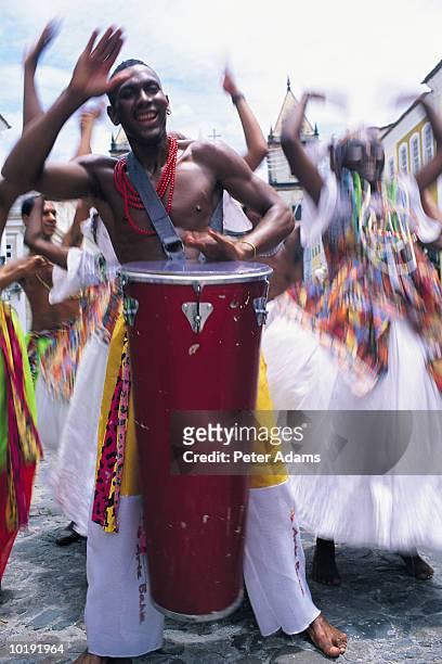 brazil, salvador, man beating drum surrounded by dancers (blurred moti - carnaval do brasil stock pictures, royalty-free photos & images