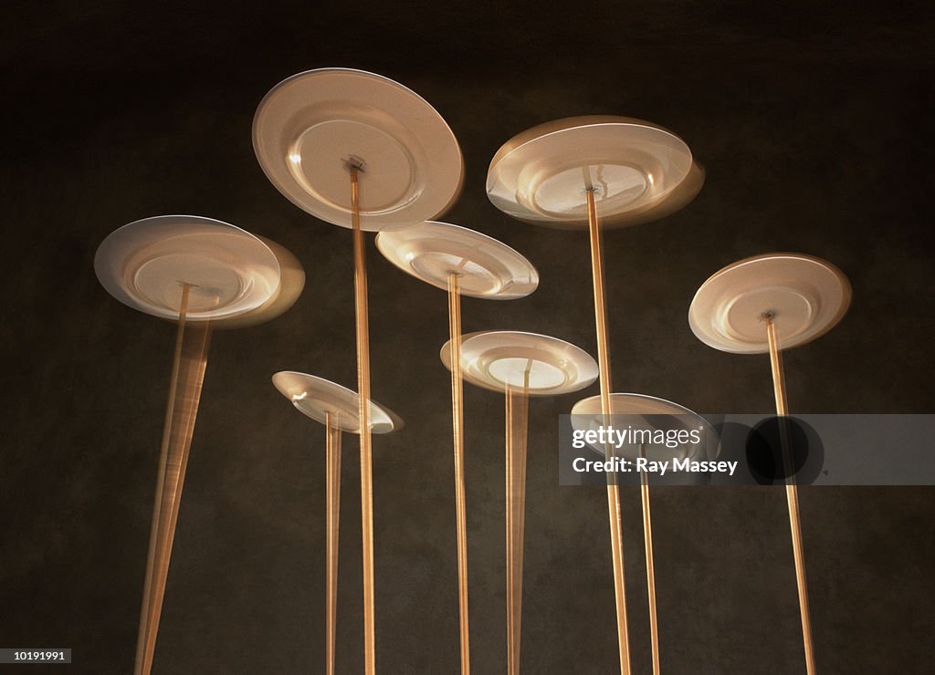 Plates spinning on poles, low angle view (blurred motion)