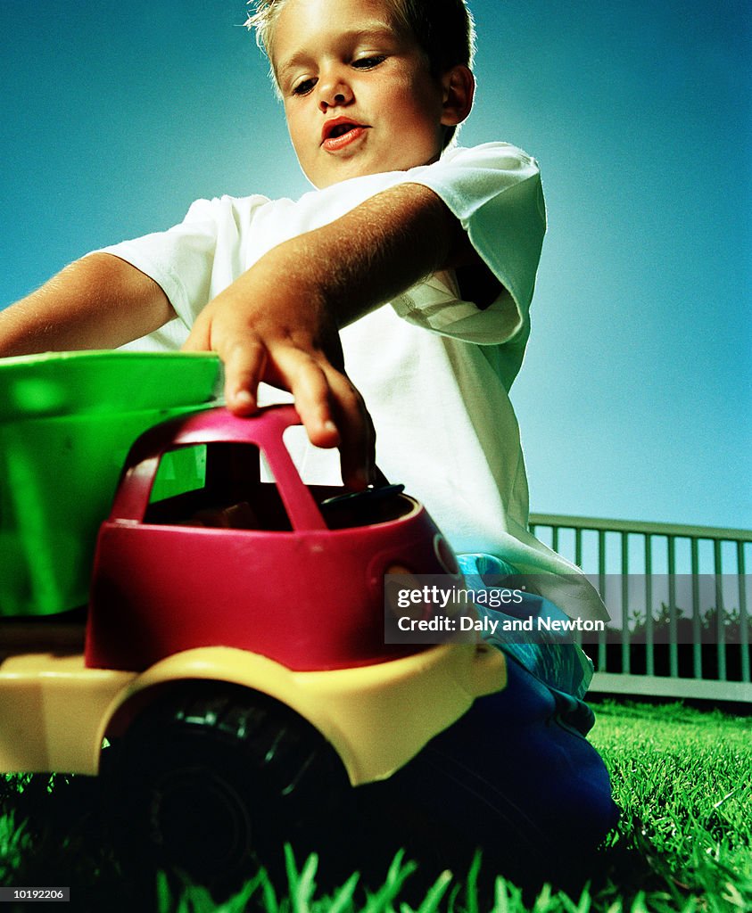 Boy (4-6) playing with toy truck, outdoors, close-up