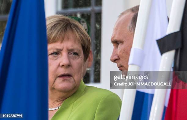 German Chancellor Angela Merkel and Russian President Vladimir Putin give a statement on August 18, 2018 at Schloss Meseberg castle in Meseberg,...