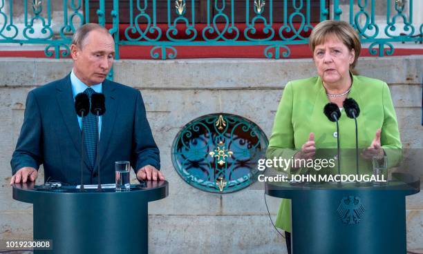 German Chancellor Angela Merkel and Russian President Vladimir Putin give a statement on August 18, 2018 at Schloss Meseberg castle in Meseberg,...