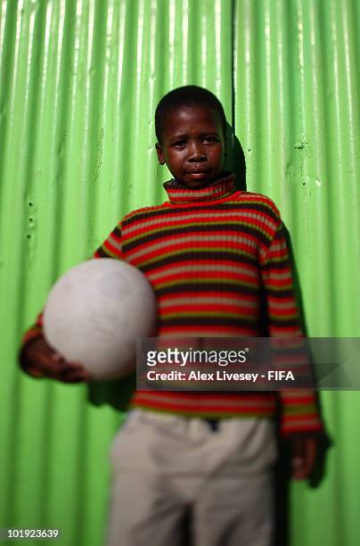 Local kid poses with his football as kids play football at the Kayelitsha Township near Cape Town on June 9, 2010 in Cape Town, South Africa.