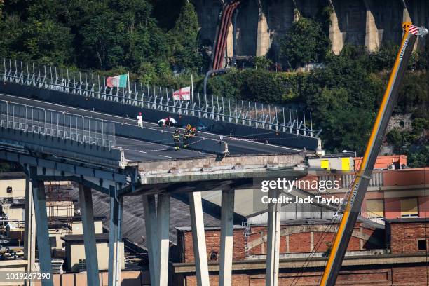 Fire fighters and workers inspect the wreckage of the Morandi Bridge days after a section of it collapsed on August 19, 2018 in Genoa, Italy. 43...