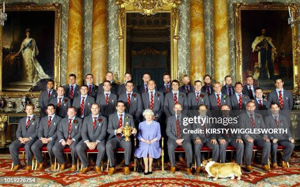 Britain's Queen Elizabeth II poses 08 December with the England rugby squad at a reception at Buckingham Palace in London to celebrate winning the...