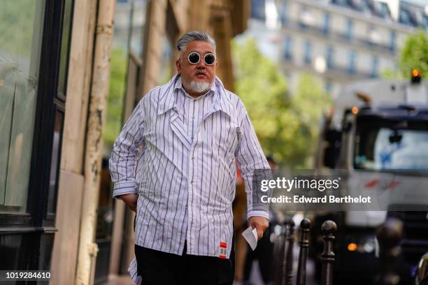 Guest wears sunglasses, a striped shirt, outside CDG Comme des Garcons, during Paris Fashion Week - Menswear Spring-Summer 2019, on June 22, 2018 in...