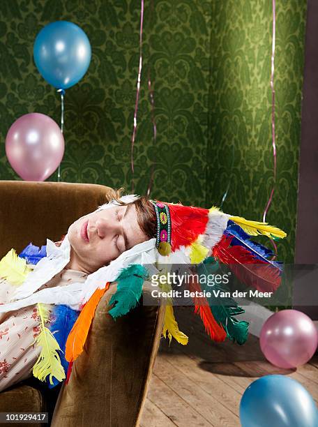 young man sleeping on sofa after party. - house after party stockfoto's en -beelden