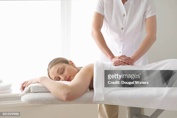 woman being treated by masseuse. - massage table stock pictures, royalty-free photos & images