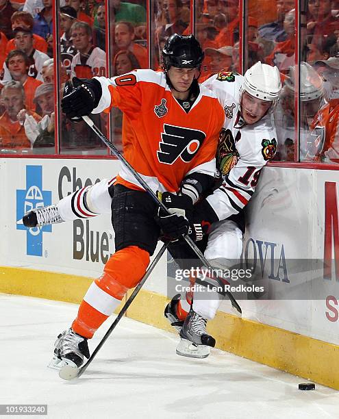 Chris Pronger of the Philadelphia Flyers pins Jonathan Toews of the Chicago Blackhawks to the boards as they chase for the loose puck in Game Six of...