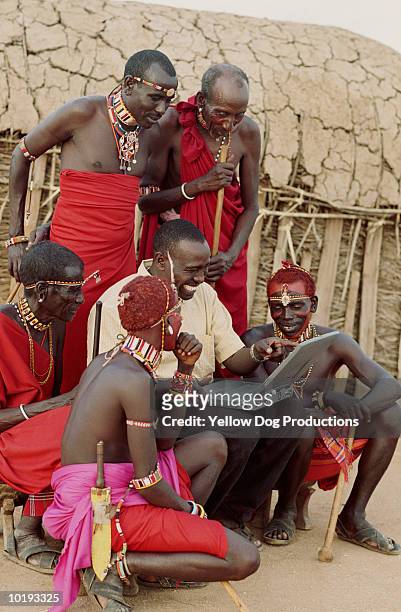 masai tribal family looking at laptop with man - tribù africana foto e immagini stock