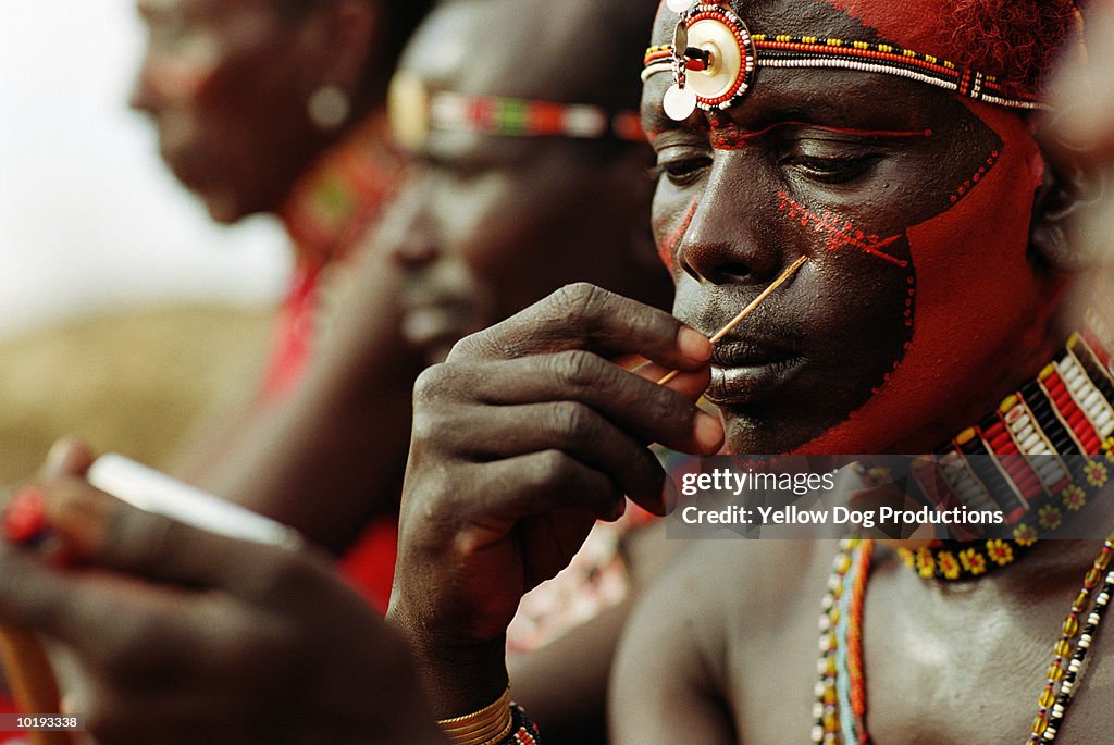Masai warrior applying face paint, close up, Kenya