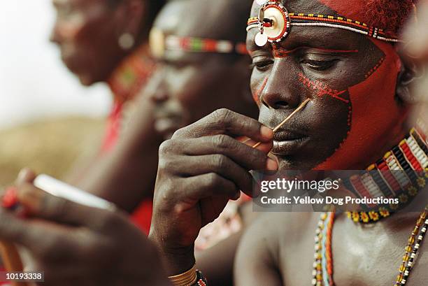 masai warrior applying face paint, close up, kenya - man face paint stock pictures, royalty-free photos & images