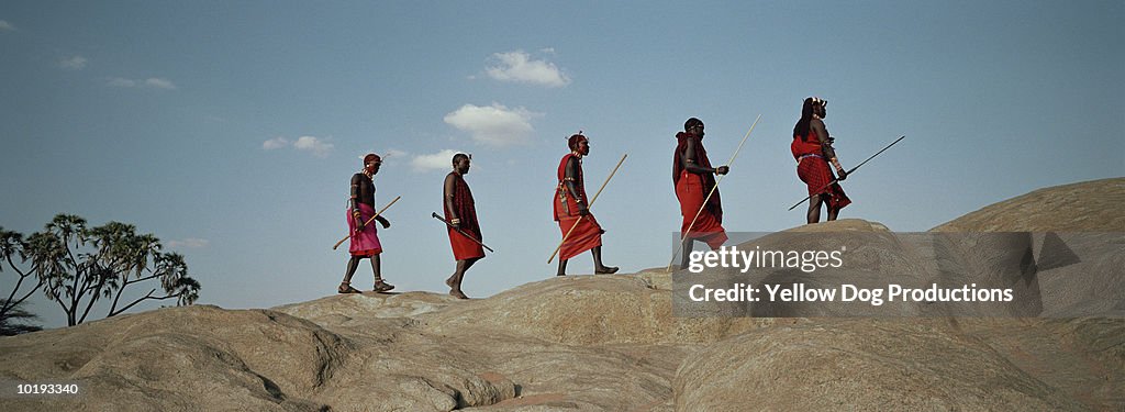 Maasai tribesmen walking along ridge, Kenya