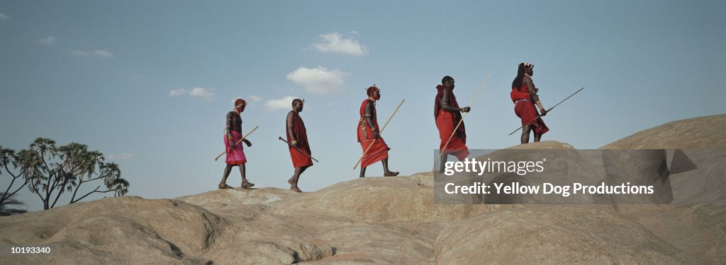 Maasai tribesmen walking along ridge, Kenya