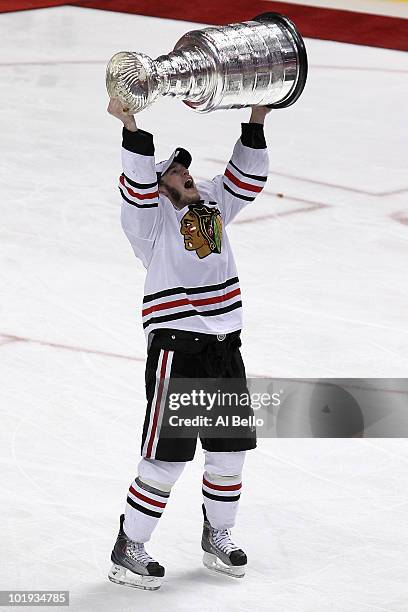 Jonathan Toews hoists the Stanley Cup after teammate Patrick Kane scored the game-winning goal in overtime to defeat the Philadelphia Flyers 4-3 and...