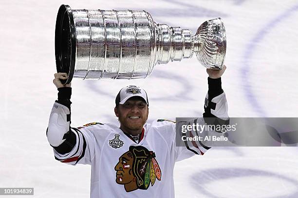 Marian Hossa of the Chicago Blackhawks hoists the Stanley Cup after teammate Patrick Kane scored the game-winning goal in overtime to defeat the...