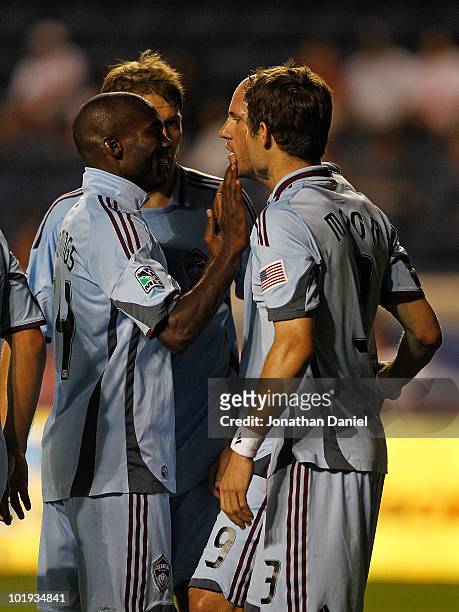 Omar Cummings of the Colorado Rapids touches the face of teammate Conor Casey during a celebration of Casey's game-tying goal with teammates Scott...