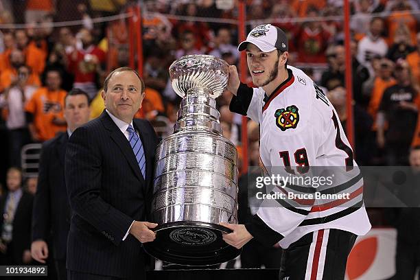 Commissioner Gary Bettman presents Jonathan Toews of the Chicago Blackhawks with the Stanley Cup after teammate Patrick Kane scored the game-winning...
