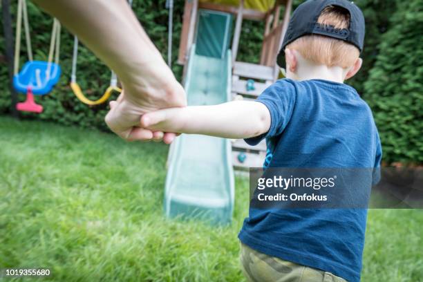 follow me concept - toddler and mother running to the playground - family garden play area stock pictures, royalty-free photos & images