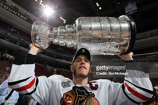 Jonathan Toews of the Chicago Blackhawks hoists the Stanley Cup after teammate Patrick Kane scored the game-winning goal in overtime to defeat the...