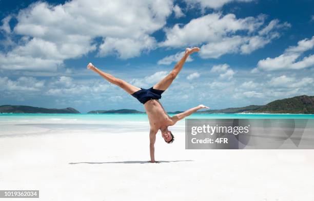 one handed stand, capoeira acrobatic yoga pose, whitsunday islands, queensland, australia - cartwheel stock pictures, royalty-free photos & images