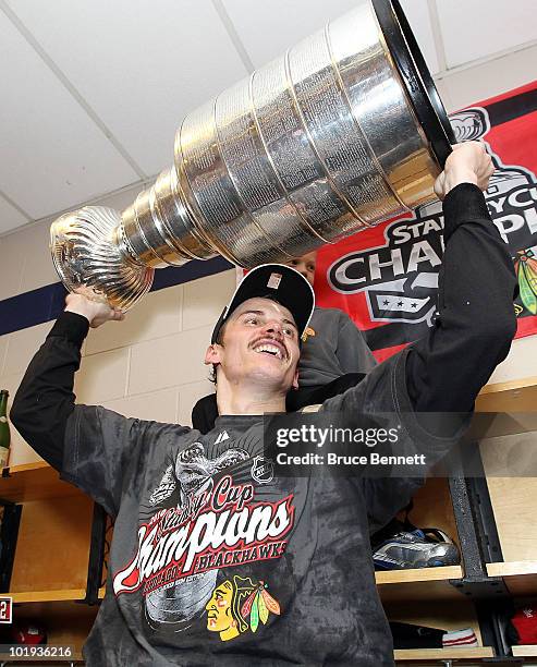 Tomas Kopecky of the Chicago Blackhawks hoists the Stanley Cup in the locker room after the Blackhawks defeated the Philadelphia Flyers 4-3 in...