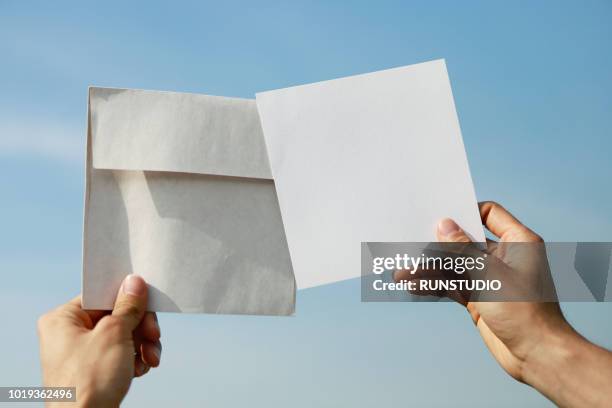 hand holding white envelope and card - hand written letter ストックフォトと画像