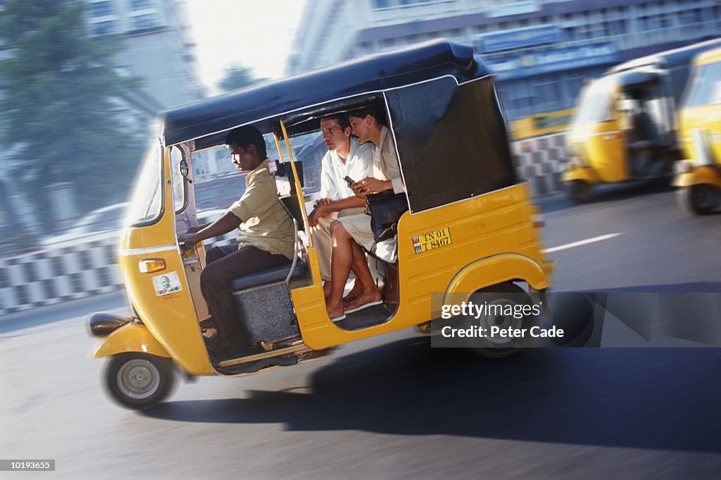 India, Madras, couple travelling in auto rickshaw (blurred motion)
