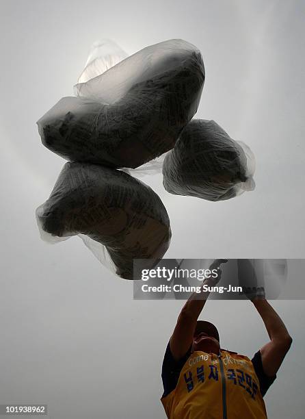 South Korean activist releases helium balloons carrying 'propaganda' leaflets destined for North Korea on June 10, 2010 in Paju, South Korea. The...