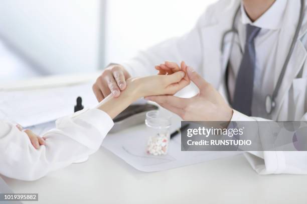 close up of doctor taking patient pulse in hospital - taking pulse fotografías e imágenes de stock