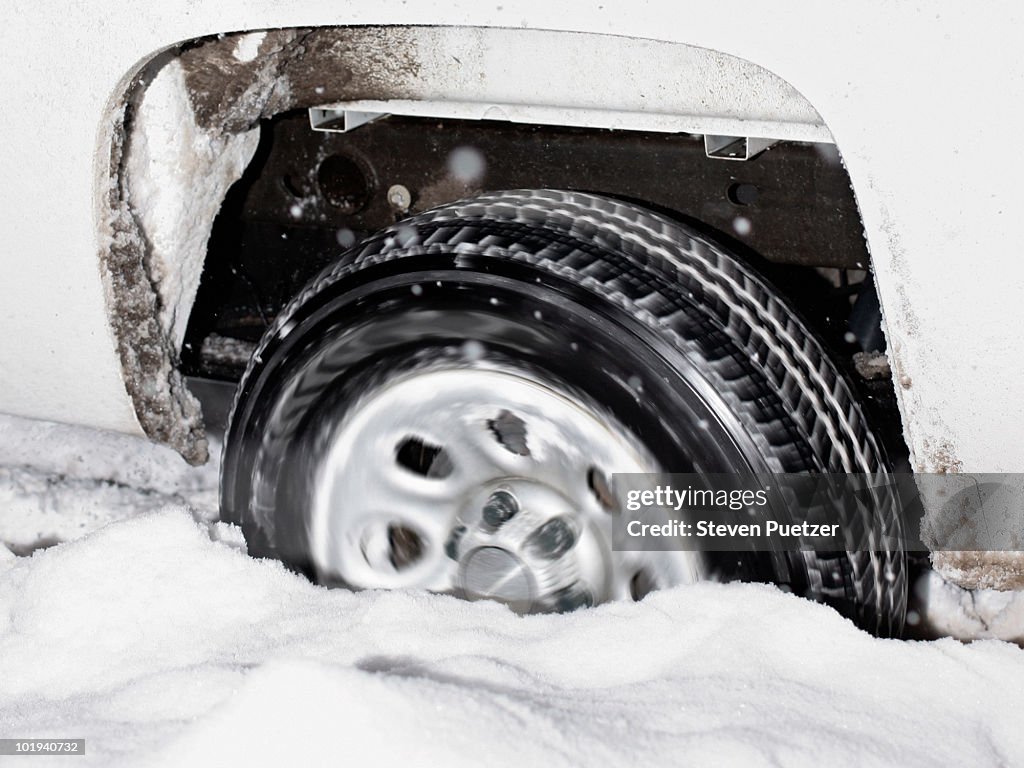 Car tire stuck in snow spinning tires