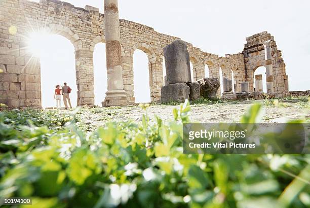 morocco, moulay idriss, roman ruins at volubilis, couple under archway - moulay idriss morocco photos et images de collection