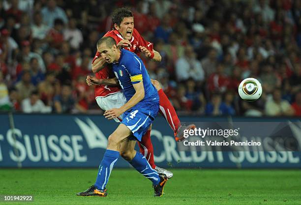 Giorgio Chiellini of Italy clashes with Benjamin Huggel of Switzerland during the international friendly match between Switzerland and Italy at Stade...