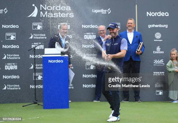 Paul Waring of England sprays champagne during the trophy ceremony during day four of the Nordea Masters at Hills Golf Club on August 19, 2018 in...