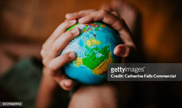 child holding a globe - 地球儀 ストックフォトと画像