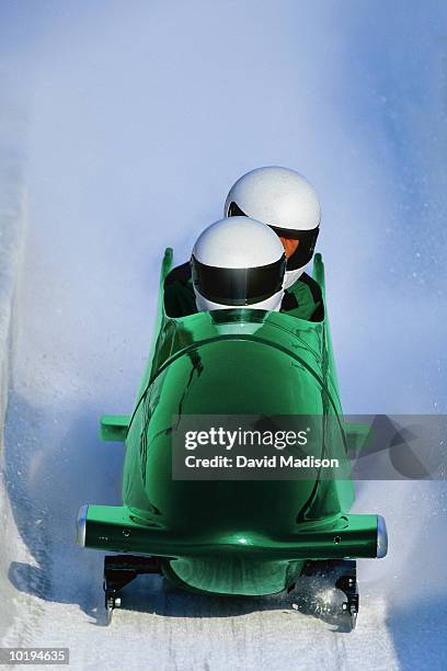 two man bob sled on track, view from front (digital enhancement) - bobsled stock pictures, royalty-free photos & images