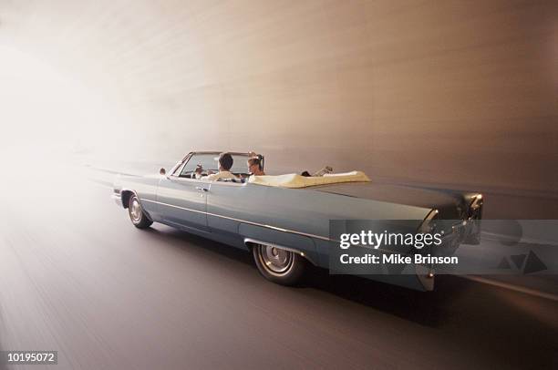 couple driving through tunnel, rear view (blurred motion) - voiture de collection photos et images de collection