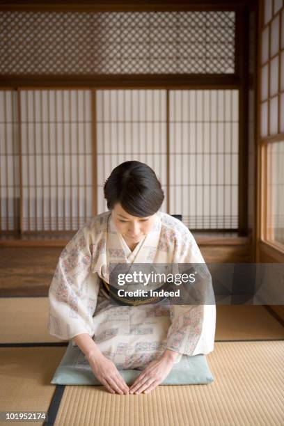 japanese woman bow her head sitting on tatami mat - saluer en s'inclinant photos et images de collection