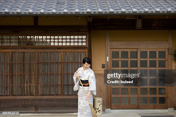 woman wearing kimono holding a broom - holding broom stock pictures, royalty-free photos & images