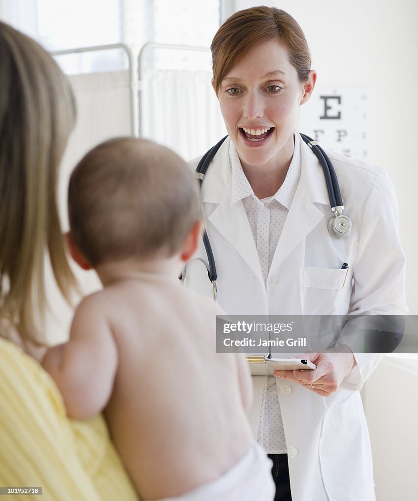 Female doctor talking to mother and baby