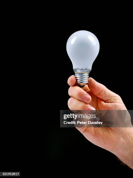 hand holding light bulb with copy space - hände glühlampe stock-fotos und bilder