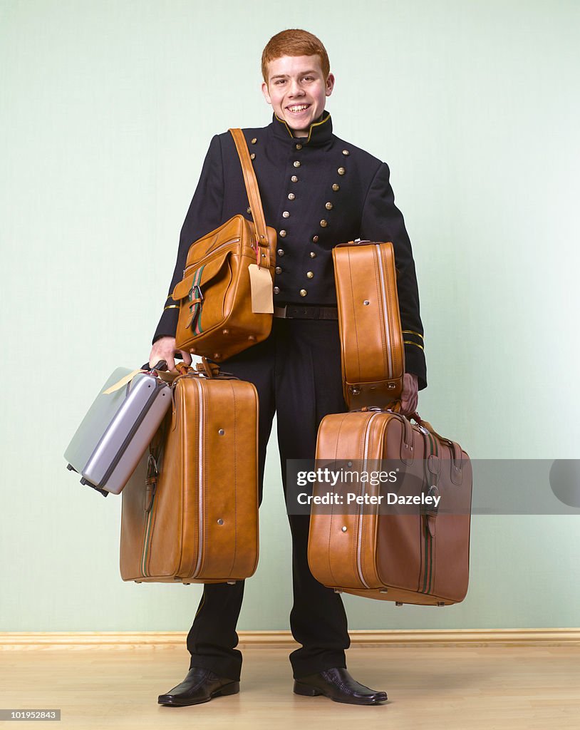 Hotel bellboy bellhop with customer luggage