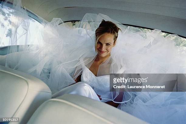 bride smiling in back of car, portrait - milestone stockfoto's en -beelden