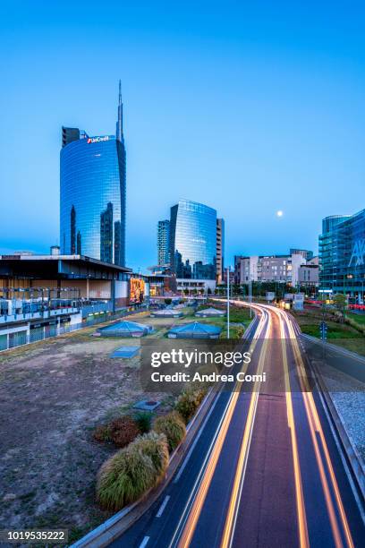 milan, lombardy, italy. skyscrapers of porta nuova business district at dusk with passing cars lights. - milano porta nuova foto e immagini stock