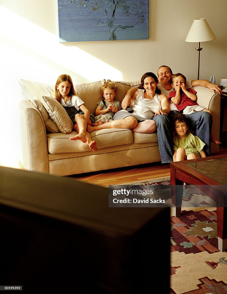 Parents and children (2-9) watching television at home, elevated view