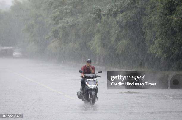 Man rides a scooter as it rains at sector 137 on August 19, 2018 in Noida, India. Light to moderate rain was recorded in many parts of Delhi, NCR...