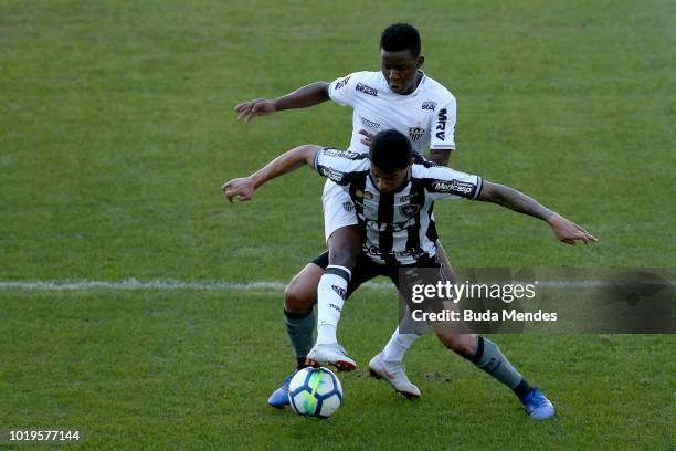 Renatinho of Botafogo struggles for the ball with Juan Cazares of Atletico during a match between Botafogo and Atletico MG as part of Brasileirao...